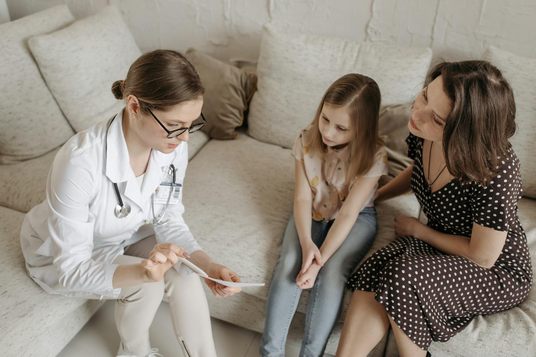 Lekarz omawia wyniki badań z kobietą i nastoletnią córką w gabinecie