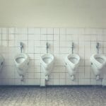 Nowoczesna, czysta toaleta męska z rzędem białych pisuarów