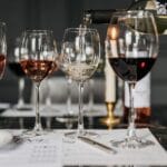 Degustacja win w eleganckim wnętrzu, kelner nalewa wino do kieliszków